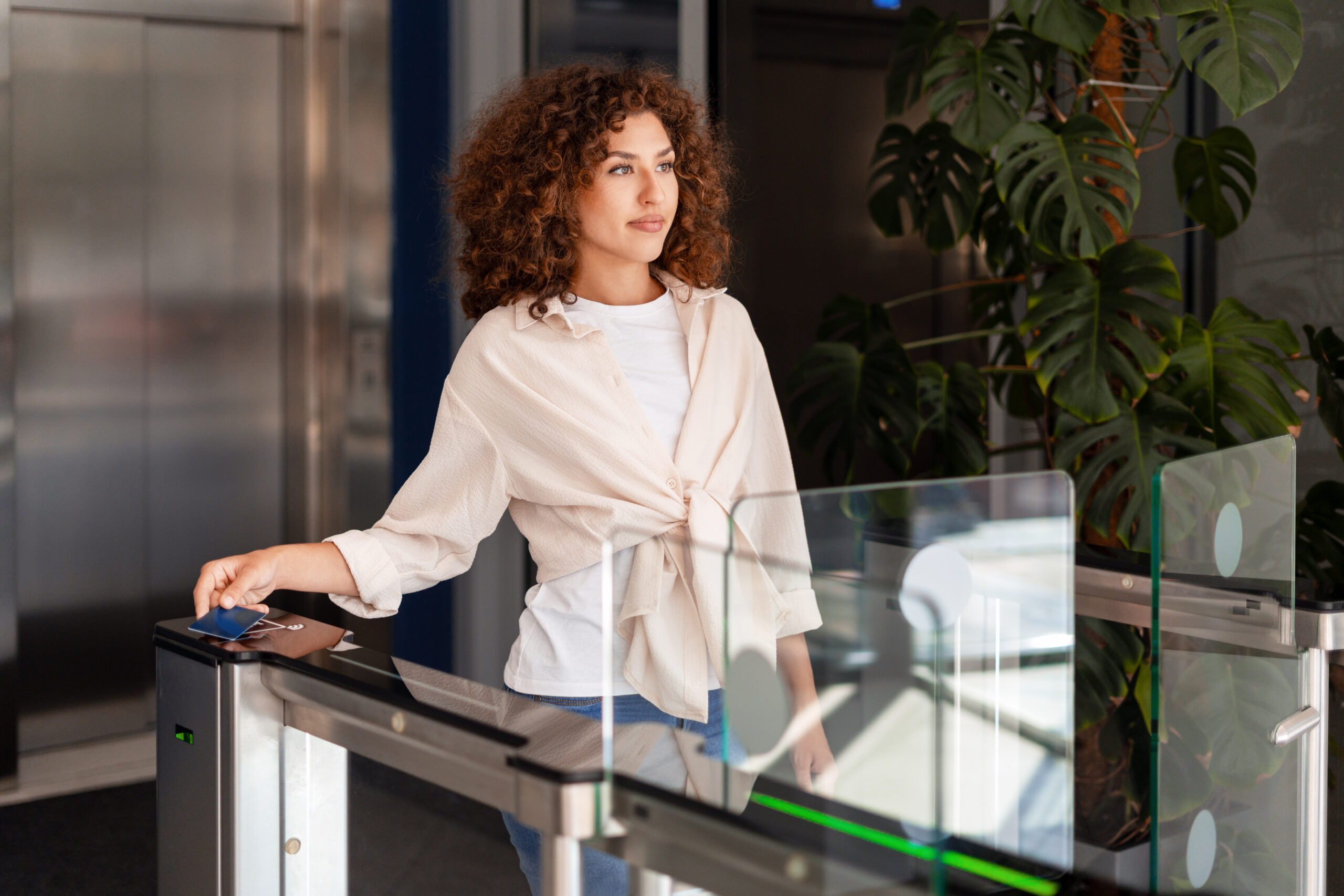 Office worker using an access card to gain entry into a modern office building, demonstrating security and professional identification